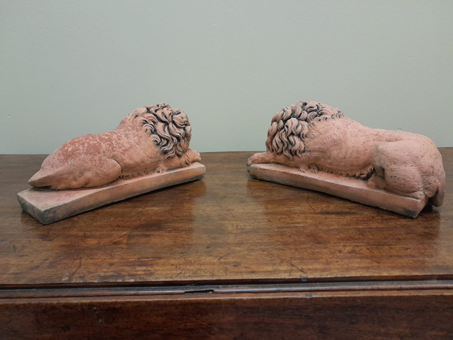 A pair of vintage recumbent terracotta lions