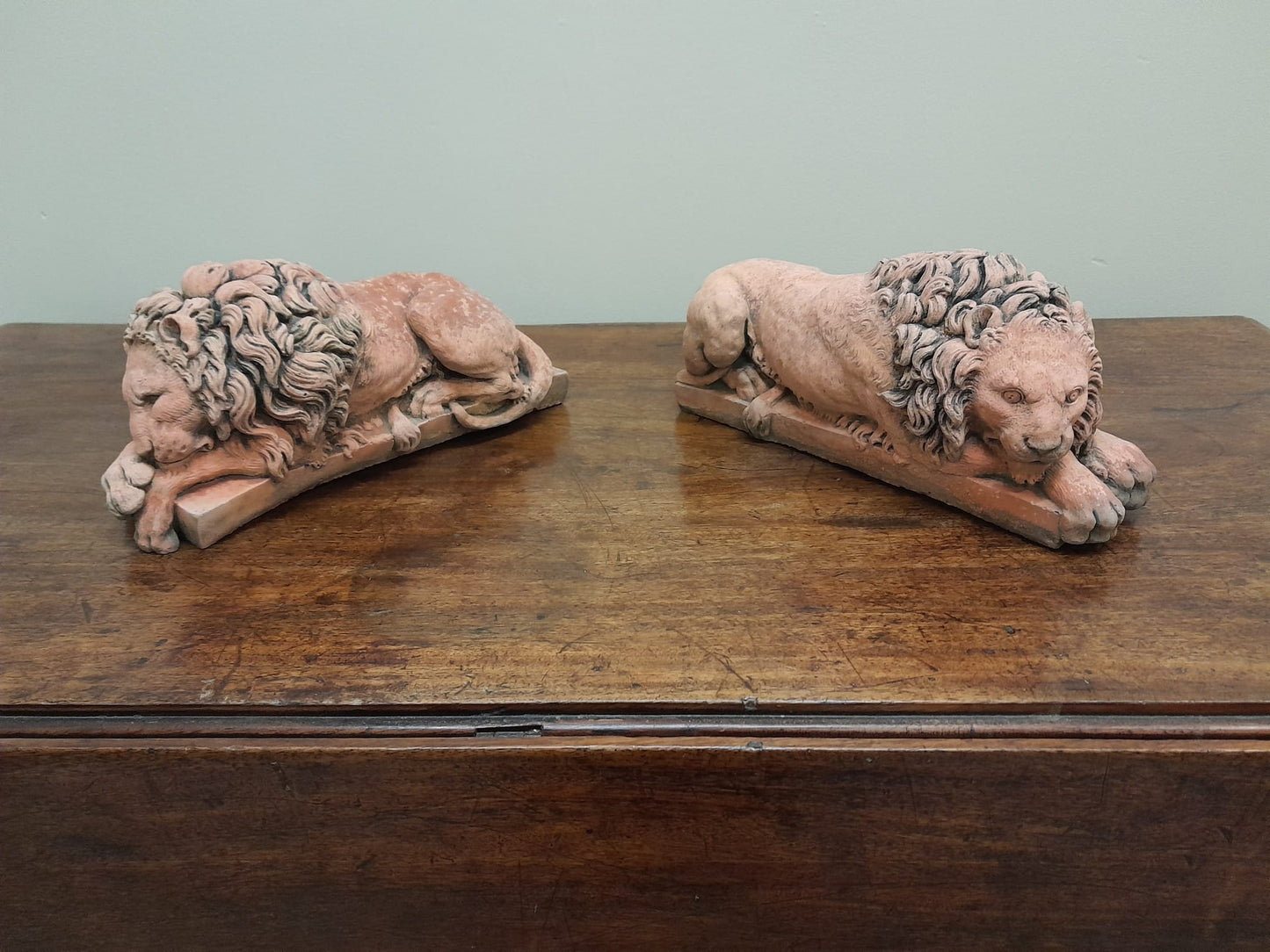 A pair of vintage recumbent terracotta lions