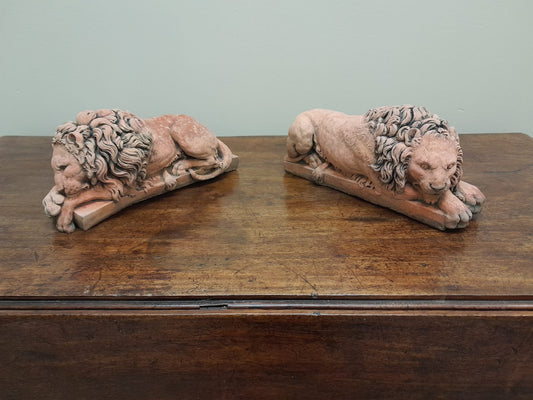 A pair of vintage recumbent terracotta lions